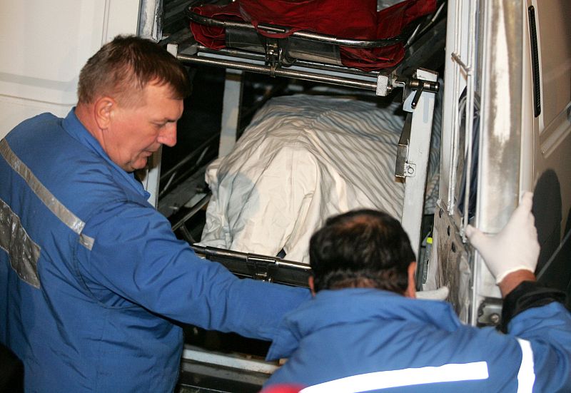 Medics push a stretcher with the body of Russian journalist Politkovskaya into an ambulance after she was found dead in central Moscow