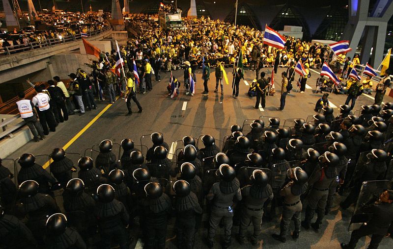 Police officers stand guard as anti-government protesters blocked the main road at Bangkok's Suvarnabhumi international airport