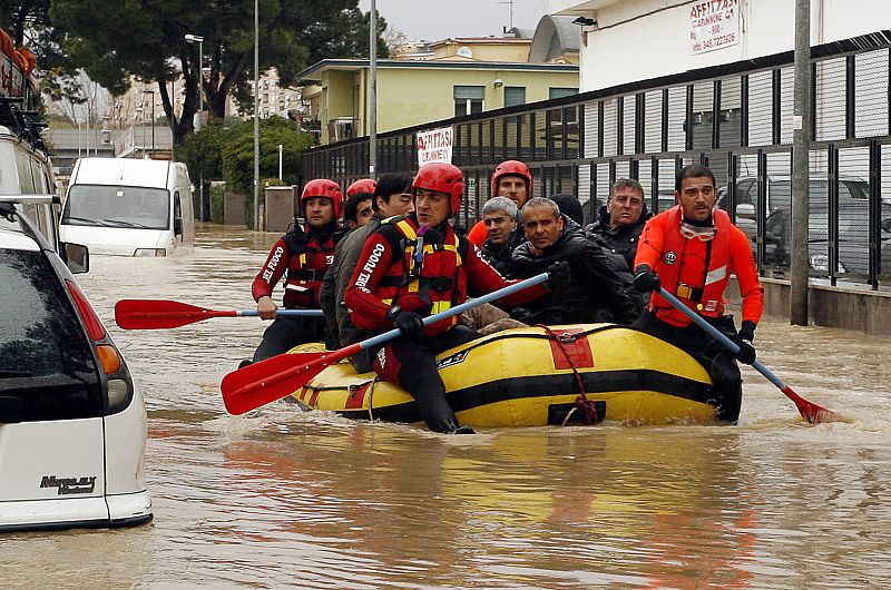 Fire department rescuers ferry stranded people through flood waters near Via Tiburtina in Rome