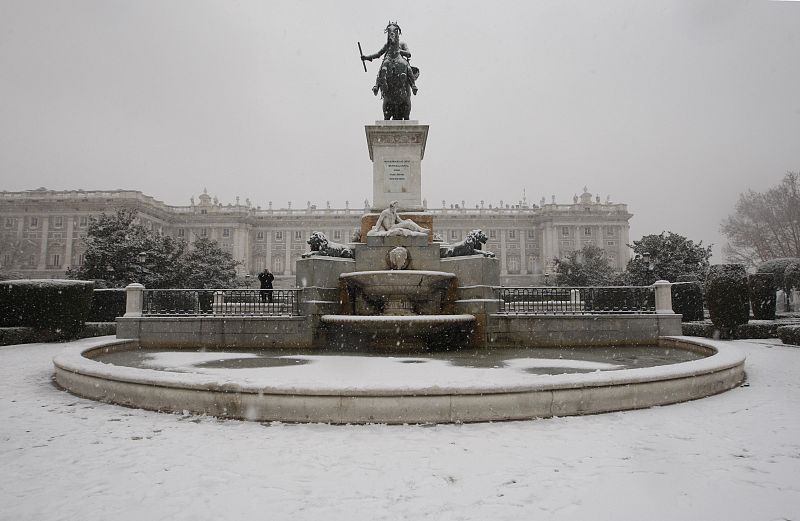 La estatua de Felipe IV en la Plaza de Oriente, con el Palacio Real al fondo, totalmente nevada.