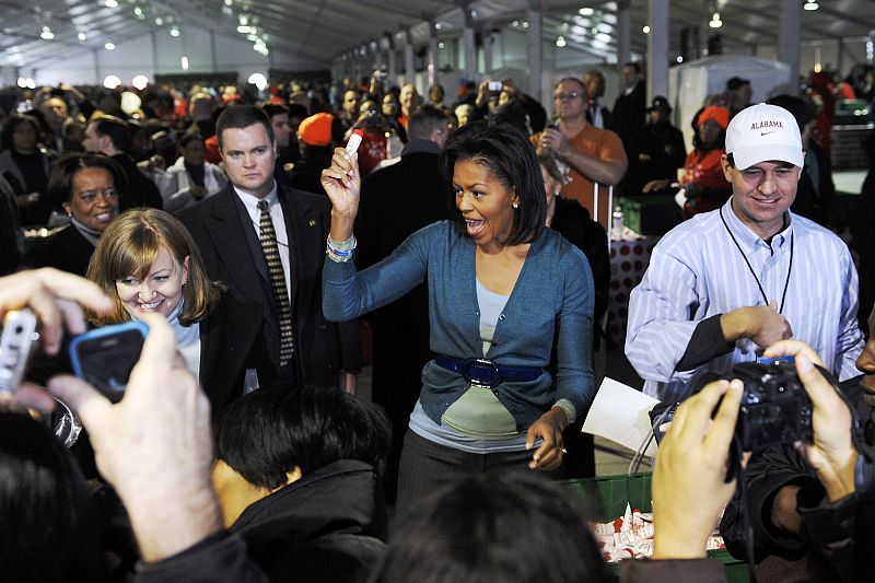 Michelle Obama holds up toiletries as she helps volunteers assemble care packages for US troops overseas in Washington