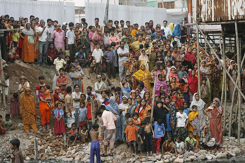 Las personas se reúnen para mirar los cuerpos de los miembros de los Rifles de Bangladesh (BDR)
