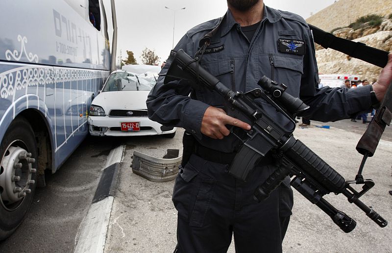 Policía israelí junto a autobús y coche policial