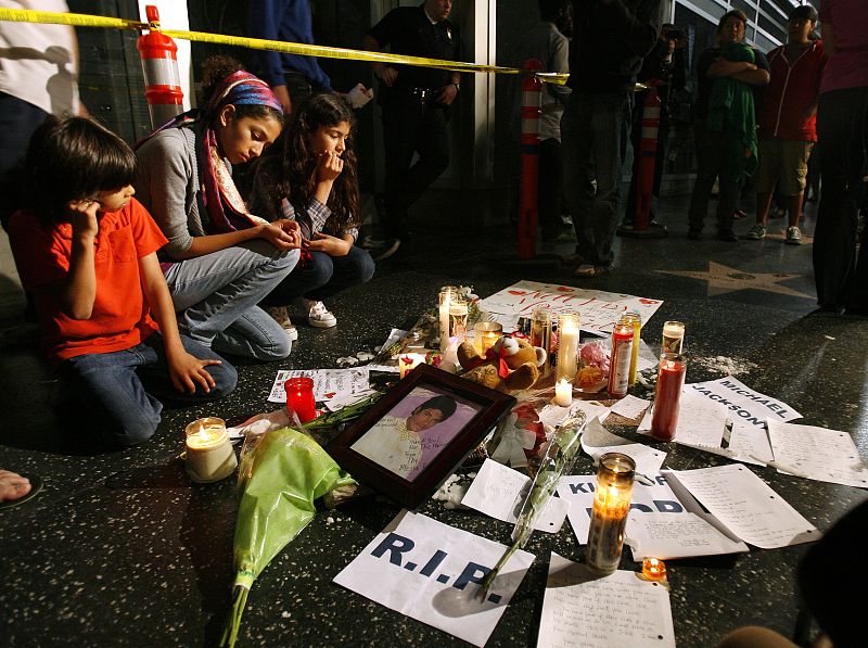 Velas, flores y notas de fans se acumulan en la estrella de Michael Jackson, personalidad de la radio y homónimo de la estrella del pop. La verdadera estrella de Jackson estaba tapada por una alfombra debido al estreno de una película.