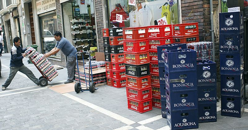 REPORTAJE PREVIO SANFERMINES. CAMIONES EN LA ESTAFETA TRABAJANDO PARA LLENAR LA BODEGA DE LOS BARES
