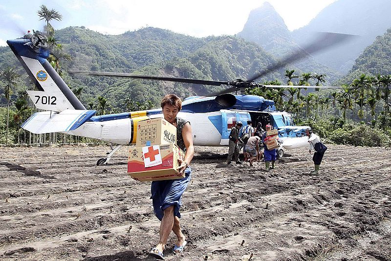 Handout photo of survivors carrying supplies from helicopter to mudslide affected village of Laiji in Chiayi county
