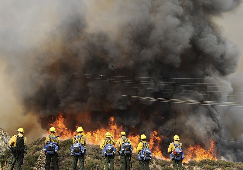Firefighters watch the Station Fire in Angeles National Forest above the La Canada Flintridge