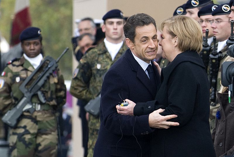El presidente francés, Nicolas Sarkozy, y la canciller alemana, Angela Merkel, se saludan de forma afectuosa en un momento de los actos conmemorativos.
