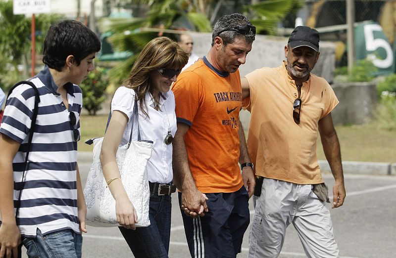 A crew member of the Spanish fishing boat Alakrana walks towards the ship with his relatives after arriving at port Victoria on the Seychelles island of Mahe