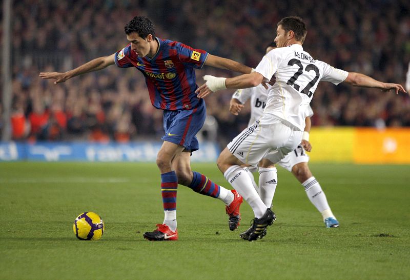 Sergio Busquets se deshace del marcaje del jugador del Real Madrid Xabi Alonso