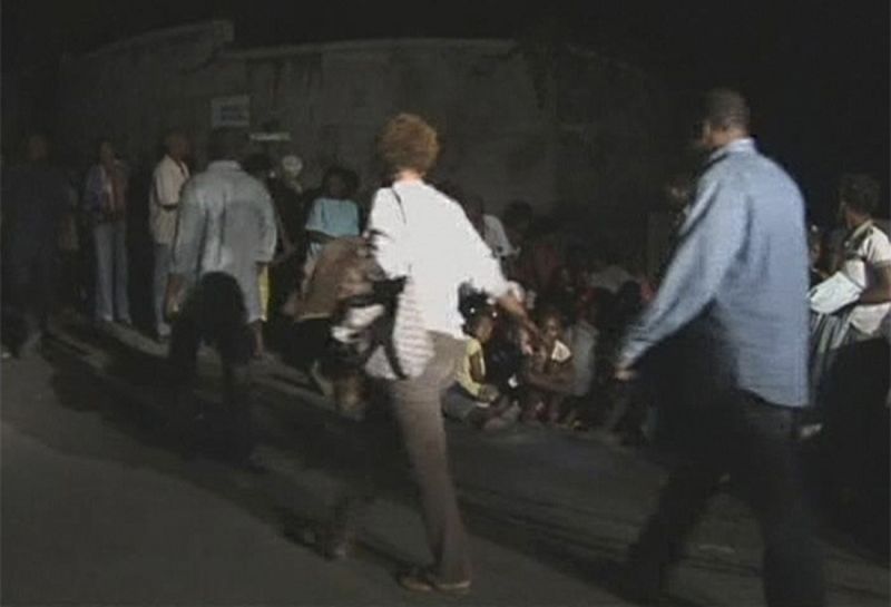 Haitians are seen on the road outside the United Nations building after a major earthquake struck, in Port-au-Prince