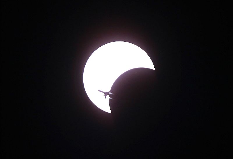 Un avión atraviesa el cielo durante el eclipse anular más largo del milenio, que se pudo ver en Asia en África.