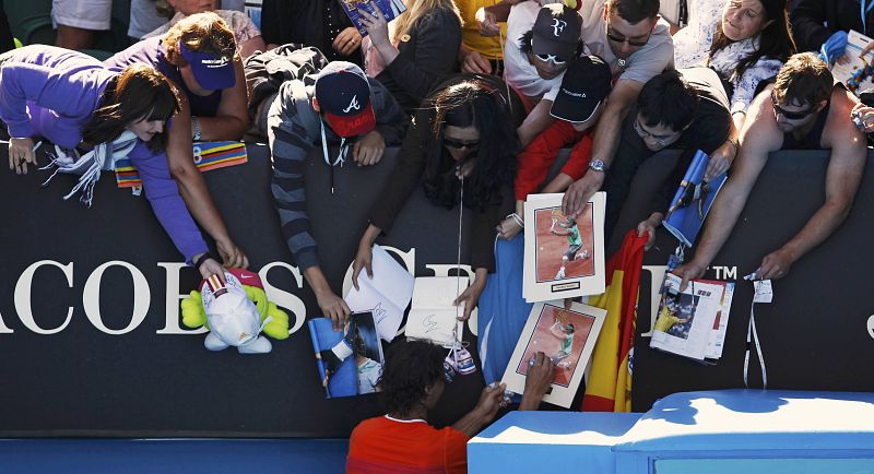 El número dos del mundo, vigente campeón del Abierto de Australia, firma autógrafos a los espectadores después del partido.