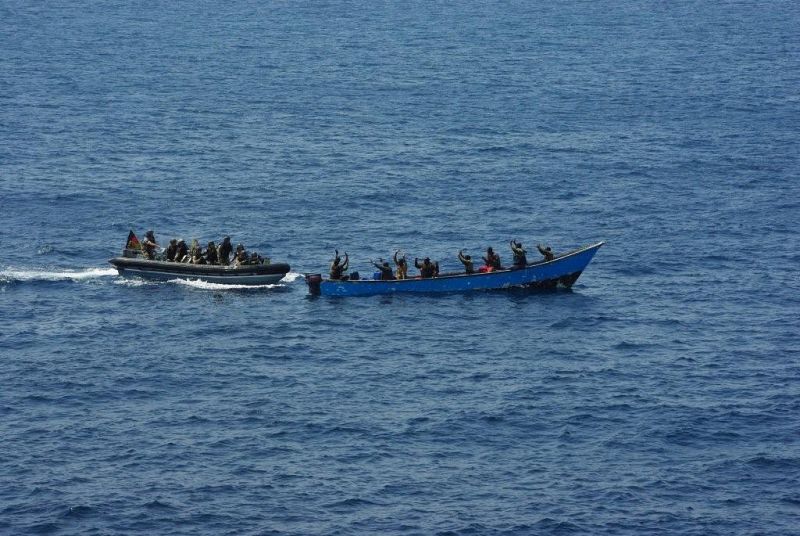 Un grupo de piratas asume, con las manos en alto, su detención por parte de militares de Atalanta.