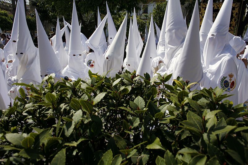 Penitents wait before taking part in the procession of La Paz brotherhood during Holy Week in Seville