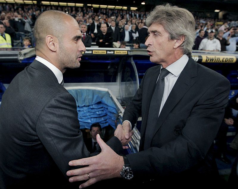 Los entrenadores del Real Madrid, el chileno Manuel Pellegrini (d), y del FC Barcelona, Pep Guardiola, se saludan al inicio del partido.