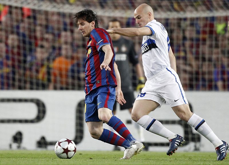 Lionel Messi lucha le balón con Cambiasso durante el partido de vueta de Champions.