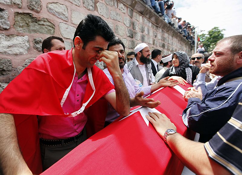 Un hombre llora desconsolada sobre el féretro de su familiar, uno de los activistas asesinados por el Ejército israelí.