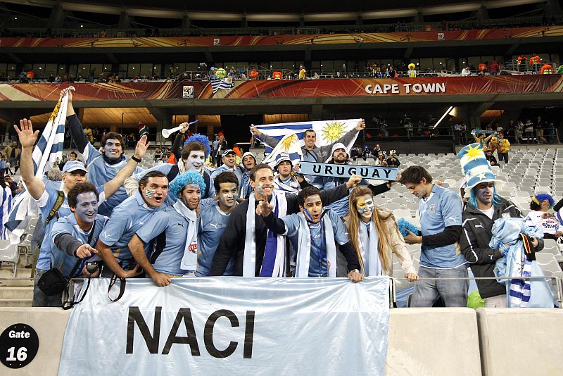 Aficionados uruguayos con los colores de su pais en las gradas del estadio Green Point