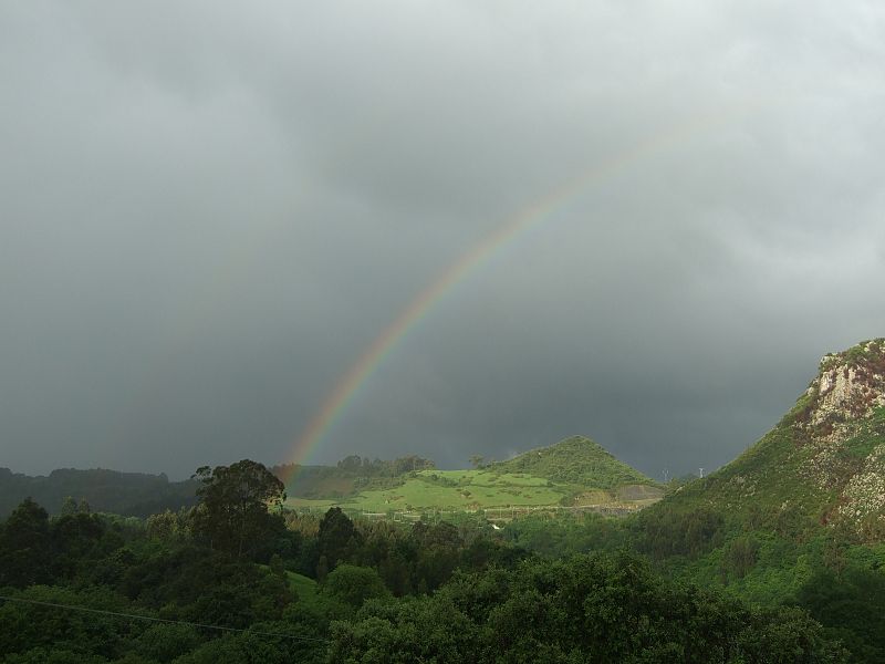 El arcoiris destaca sobre un cielo cubierto de nubes en la montaña cántabra.