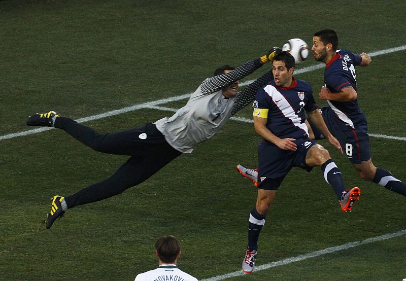Slovenia's goalkeeper Samir Handanovic punches the ball away from Carlos Bocanegra and Clint Dempsey (R) of the U.S. during their 2010 World Cup Group C soccer match at Ellis Park stadium in Johannesburg