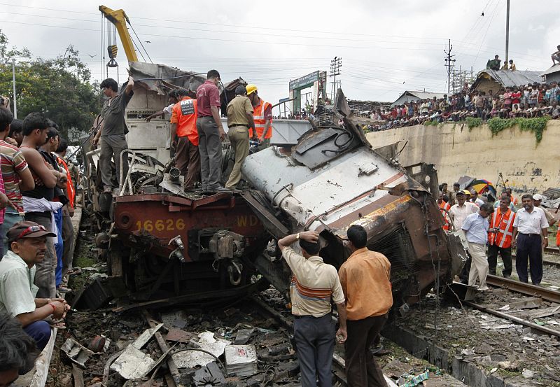 Equipos de rescate y curiosos se agolpan cerca de los restos del tren en el lugar del acccidente, que se ha producido en Sainthia, al este del país.