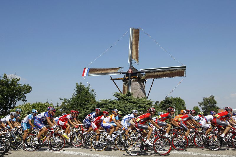 Riders cycle past a windmill during the first stage of the Tour de France cycling race from Rotterdam to Brussels
