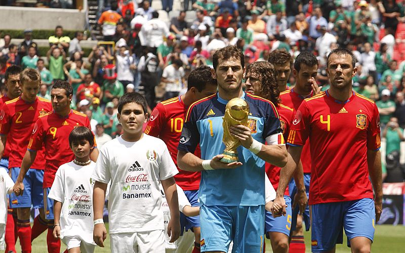 Iker Casillas lleva la Copa FIFA en sus manos mientras entra a la cancha con sus demás compañeros para enfrentar a México.