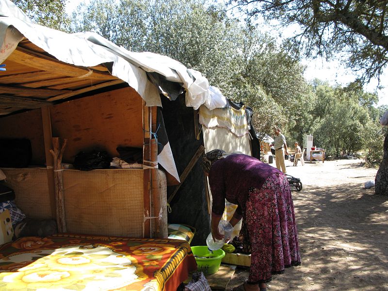 Una de las rumanas más mayores del campamento echa agua en un barreño para lavar