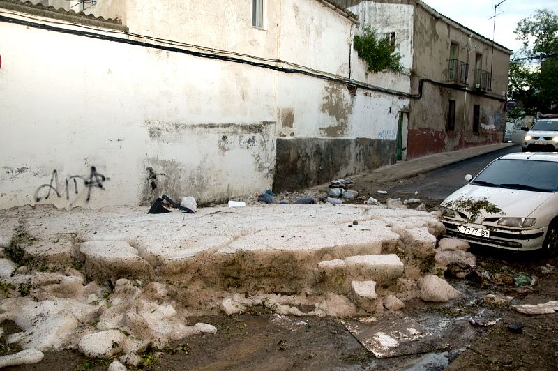 Los restos de la tormenta de granizo, junto a uno de los muchos coches afectados, aún se pueden apreciar ocho horas después