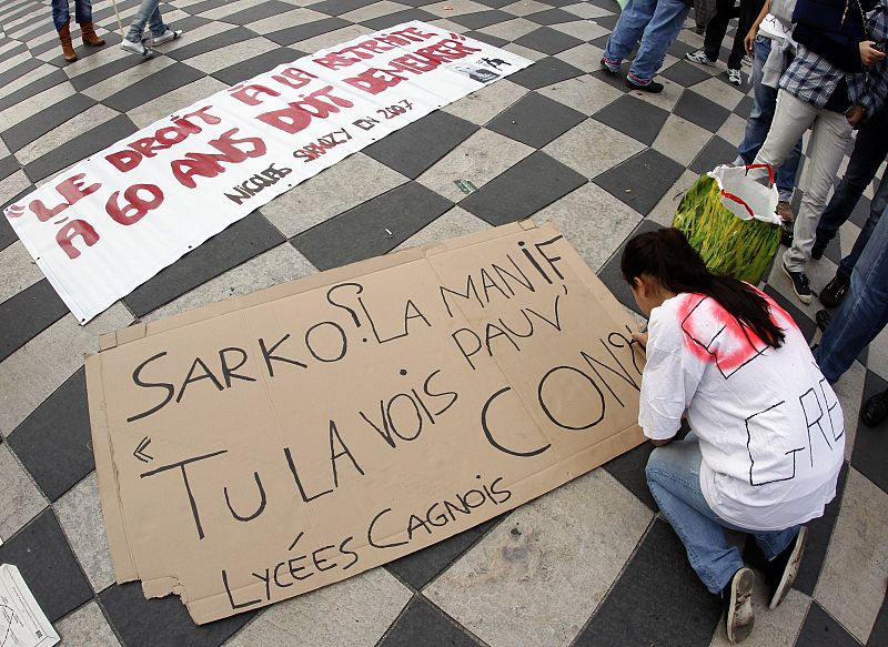 Un estudiante escribe una de las pancartas en protesta por la reforma de las pensiones