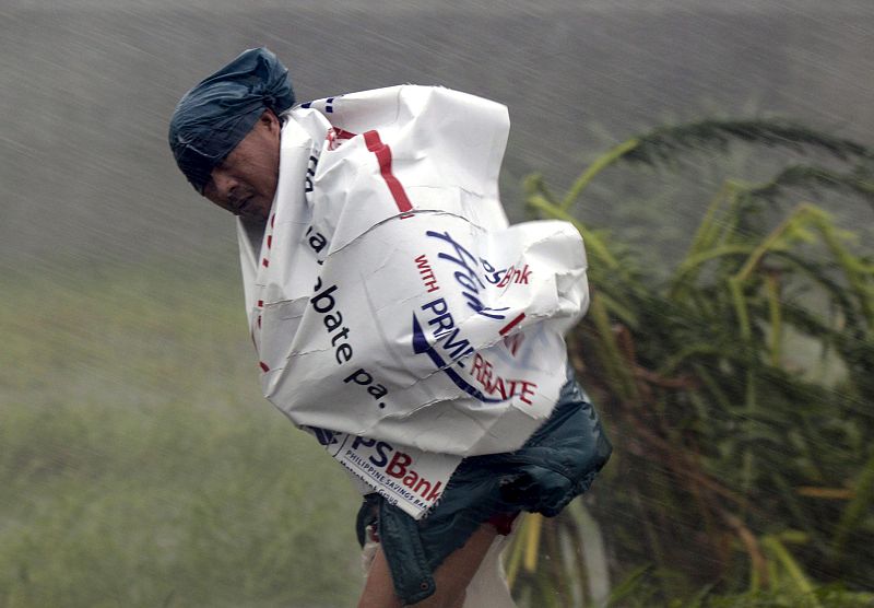 Un campesino lucha contra la fuerza del viento del Tifón 'Megi', que ha impactado de lleno en el norte de Filipinas