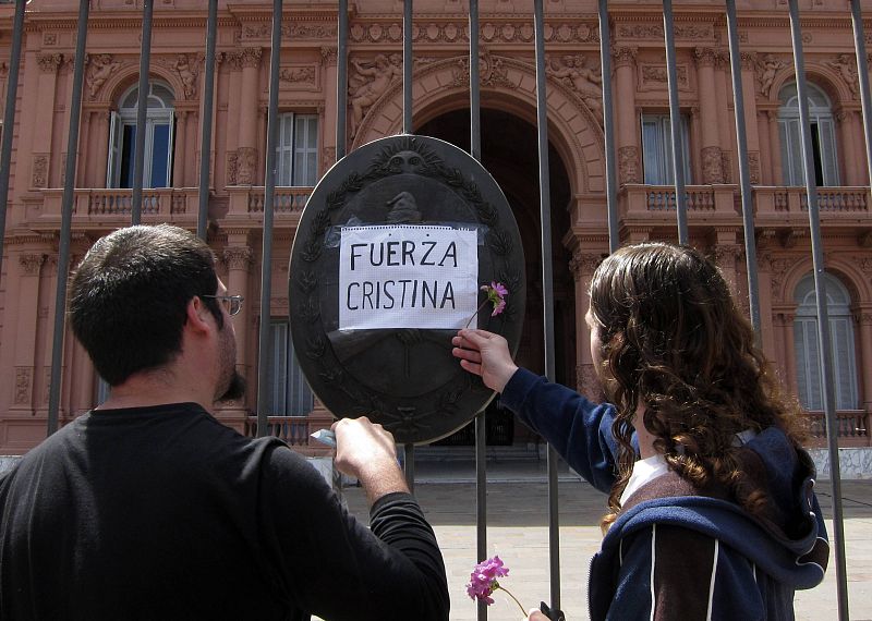 Dos hombres ponen una pancarta de apoyo a Cristina Fernández, presidenta de Argentina y viuda de Néstor Kirchner, en la puerta de la Casa Rosada tras conocerse la muerte del ex presidente