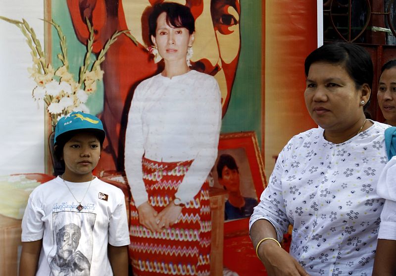 Supporters stand in front of a poster of Aung San Suu Kyi at the headquarters of her party NLD in Yangon