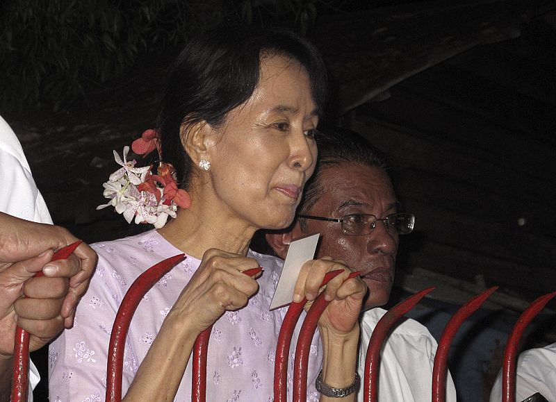 Aung San Suu Kyi speaks to supporters outside her home, which she was placed under house arrest for seven years, in Yangon