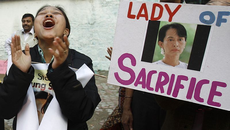Supporter of Myanmar's pro-democracy leader Suu Kyi applauds next to her portrait during celebrations in New Delhi