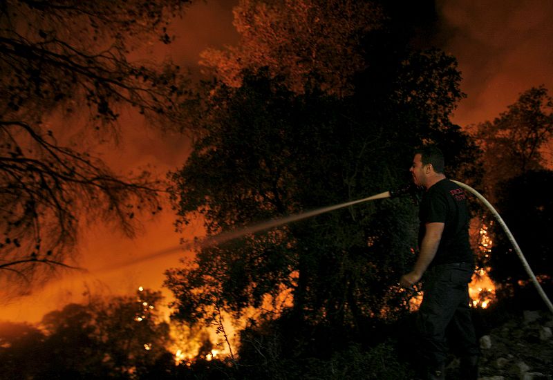 Un bombero lucha contra las llamas en el bosque Carmel.
