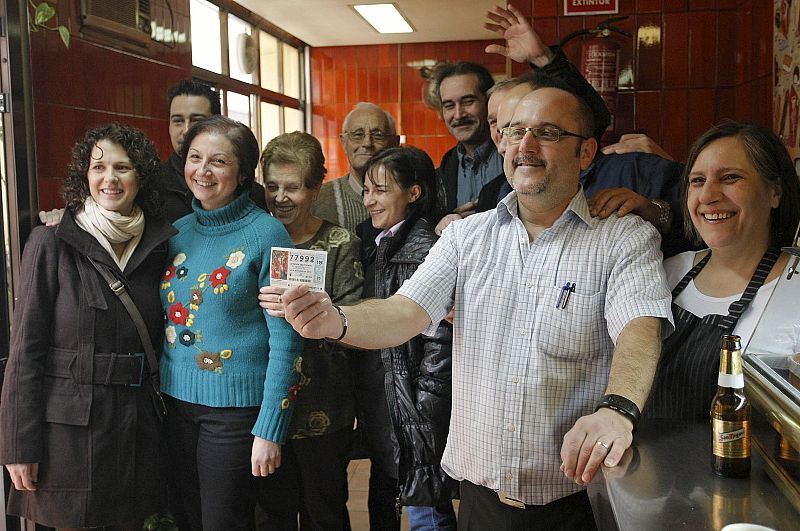 Responsables y clientes del bar El Toledano, en Castellón, que ha repartido un millón de euros en el sorteo extraordinario de lotería de Navidad al vender veinte series del quinto premio 77.992.