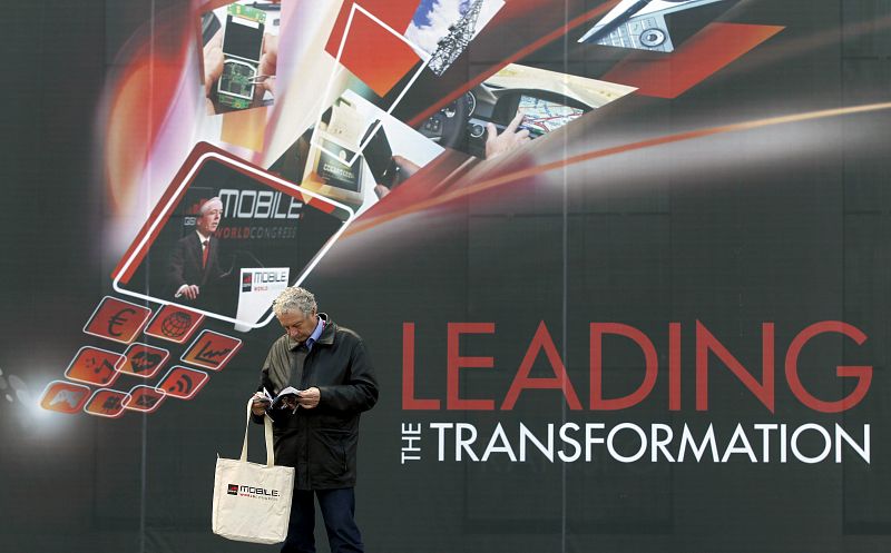 Un hombre consulta la documentación del Mobile World Congress,el congreso más importante del mundo sobre telefonía móvil que organizan operadores y fabricantes