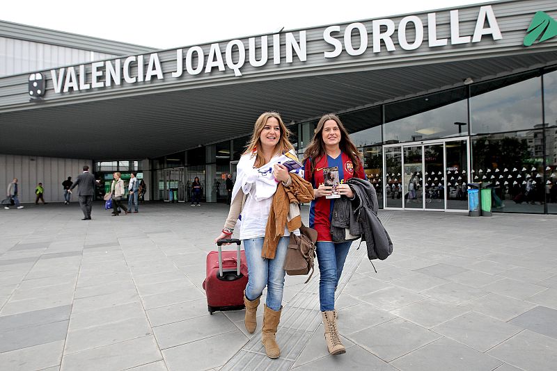 Dos jóvenes aficionadas, una del Real Madrid y otra del FC Barcelona, a su llegada esta mañana a la estación Joaquín Sorolla del AVE de Valencia