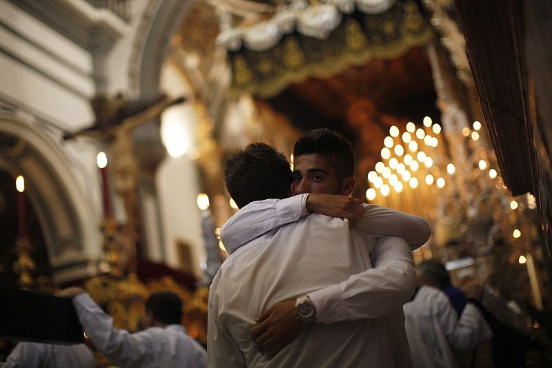 Los miembros de una cofradía de Málaga lloran en el interior de la iglesia después de que la Hermandad haya decidido cancelar la procesión debido a la lluvia