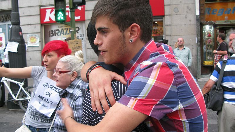 Algunos voluntarios regalan abrazos entre los transeúntes,