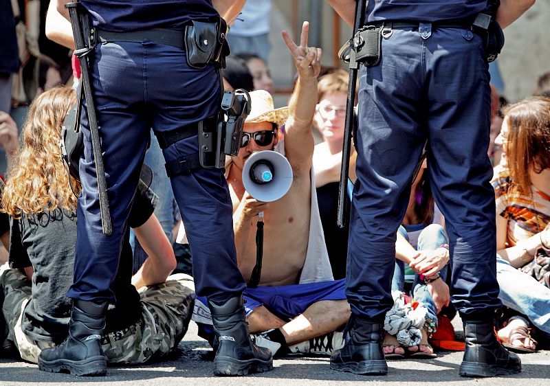 Agentes de la Policía Nacional vigilan a un grupo de manifestantes durante la protesta del movimiento 15-M