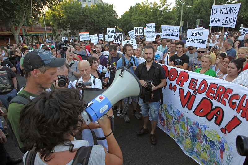 Varios indignados muestran su pancarta durante la protesta del movimiento 15M iniciado en la plaza de Atocha, en Madrid.