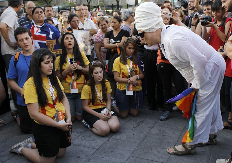 Uno de los manifestantes alecciona a un peregrino durante la manifestación que rechaza el gasto que ha generado la visita del papa.