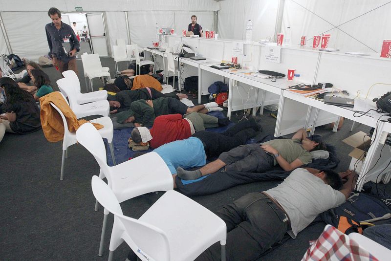 Los periodistas apuran los últimos momentos para descansar en el aeródromo de Cuatro Vientos antes de que comience la misa que oficiará el papa Benedicto XVI