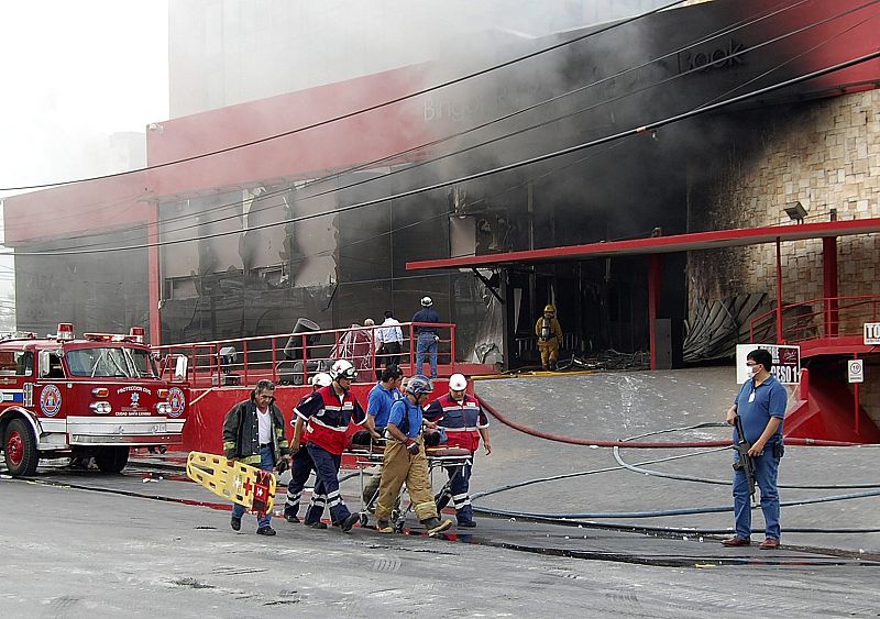 Un grupo de bomberos traslada a uno de los heridos en el ataque