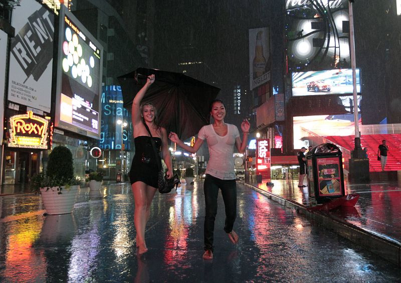 Dos jóvenes bailan bajo la lluvia que ha dejado 'Irene' al llegar a Nueva York.