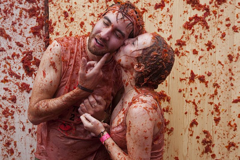 Una pareja cubierta de tomate se besa durante la Tomatina de Buñol (Valencia)
