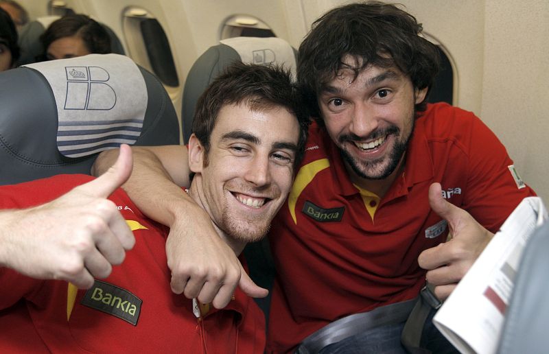 Los jugadores de la selección española de baloncesto Víctor Claver (i) y Víctor Sada, en el avión que traía de regreso al equipo después de proclamarse campeón de Europa al derrotar a Francia en la final por 98-85 ayer en Kaunas (Litaunia).